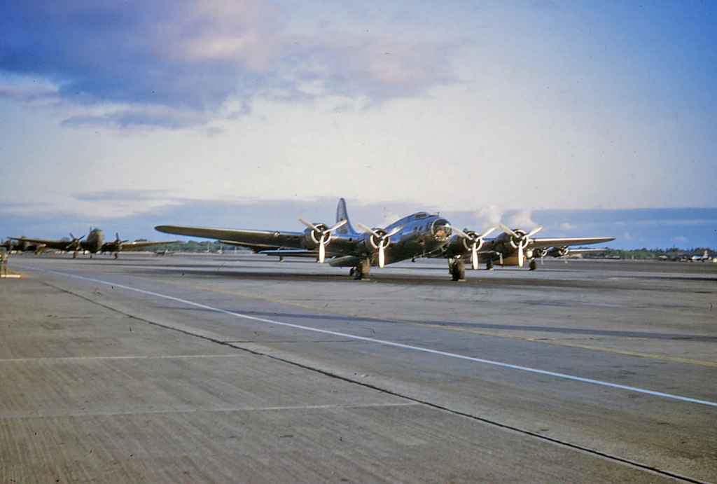 A World War II surplus Boeing B-17 and an army olive four-bladed C-46 Commando at rest on the Hickam apron, late 1940s.