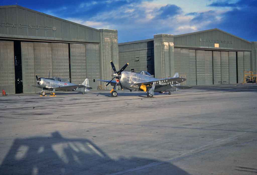 USAF P-47D Thunderbolt and a North American T-6 Texan, both looking very new with factory polished metal fuselage and wing surfaces. This images taken at Hickam probably dates from just after the end of World War II.