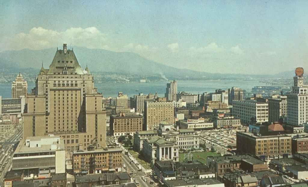 Hotel Vancouver scenic view circa 1954, along with a section of downtown showing the Court House Square, Vancouver Harbour, North Vancouver and the North Shore mountains. (Postcard published by Natural Color Productions Ltd., Vancouver, B.C.)