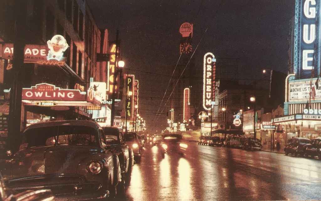 Night scene of Vancouver, BC, Canada, showing a portion of the theatre district. Vancouver is known for its high concentration of neon in the downtown area. We can date this image to 1955, the year the film "Above Us the Waves" staring John Mills was released theatrically. (Postcard published by Vancouver Magazine Services LTD., Vancouver, BC)